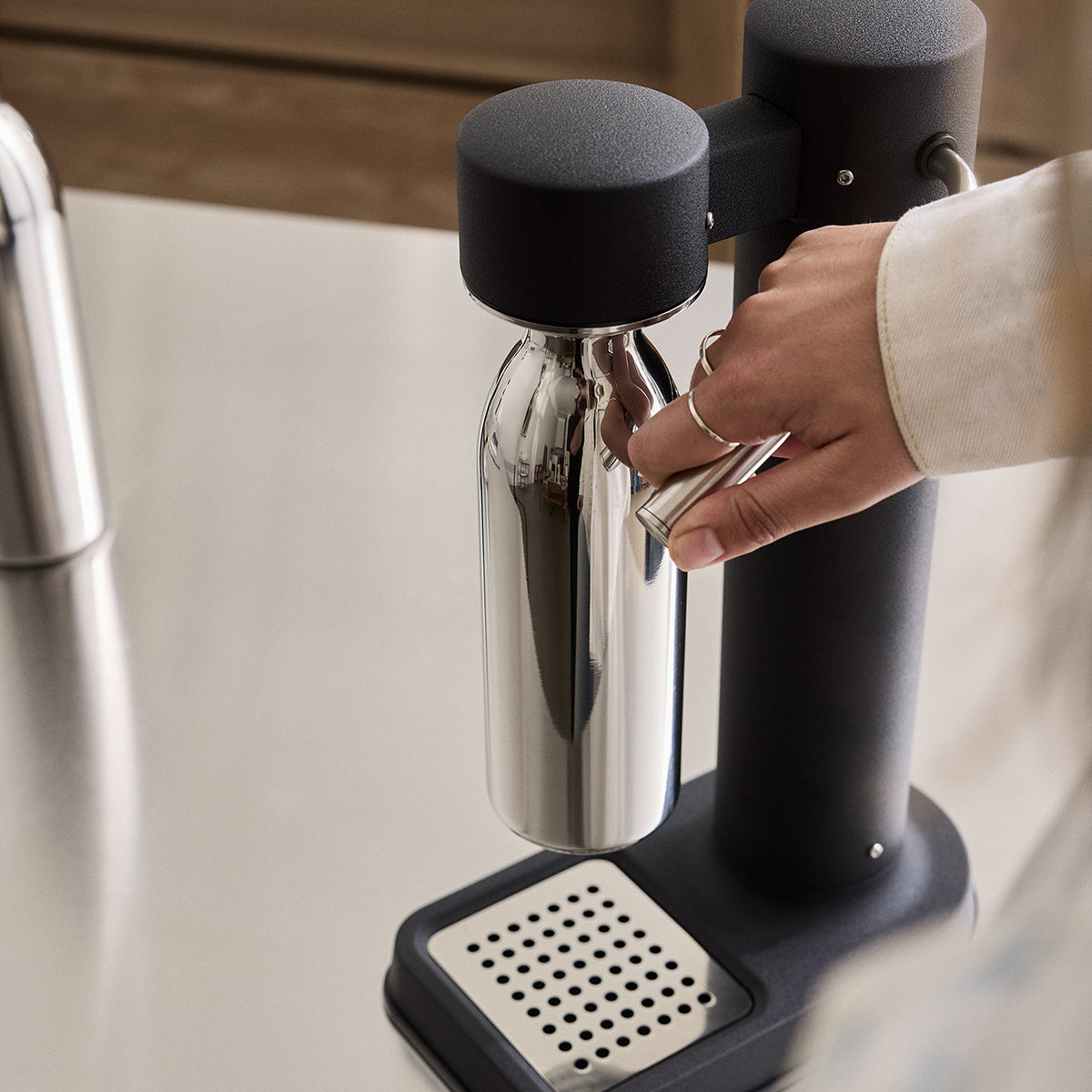 Close up of 650ml Stainlesss steel bottle attached to Black Carbonator 3 on kitchen bench