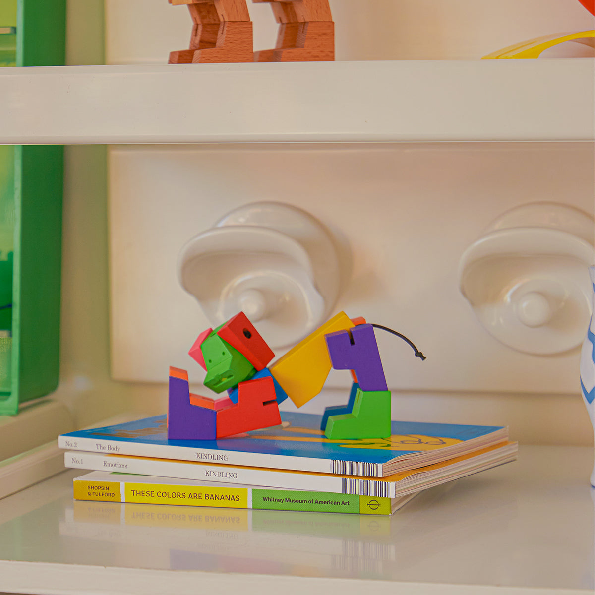 Cubebot milo small multi stretching on pile of books