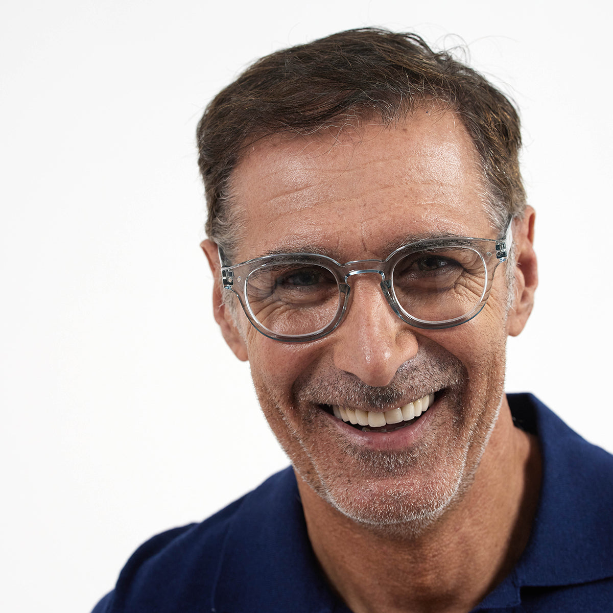 Man wearing Izipizi shape c frozen blue reading glasses on white background with grey hair and navy tshirt