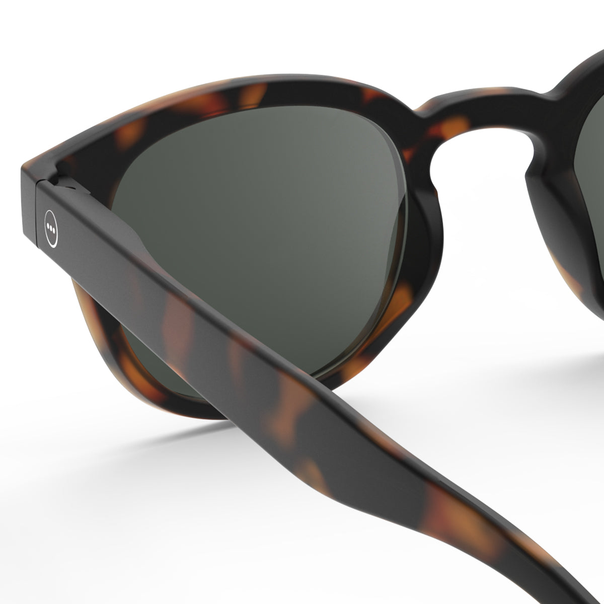 Leaning man wearing Izipizi shape c tortoise sunglasses wearing a cream jumper