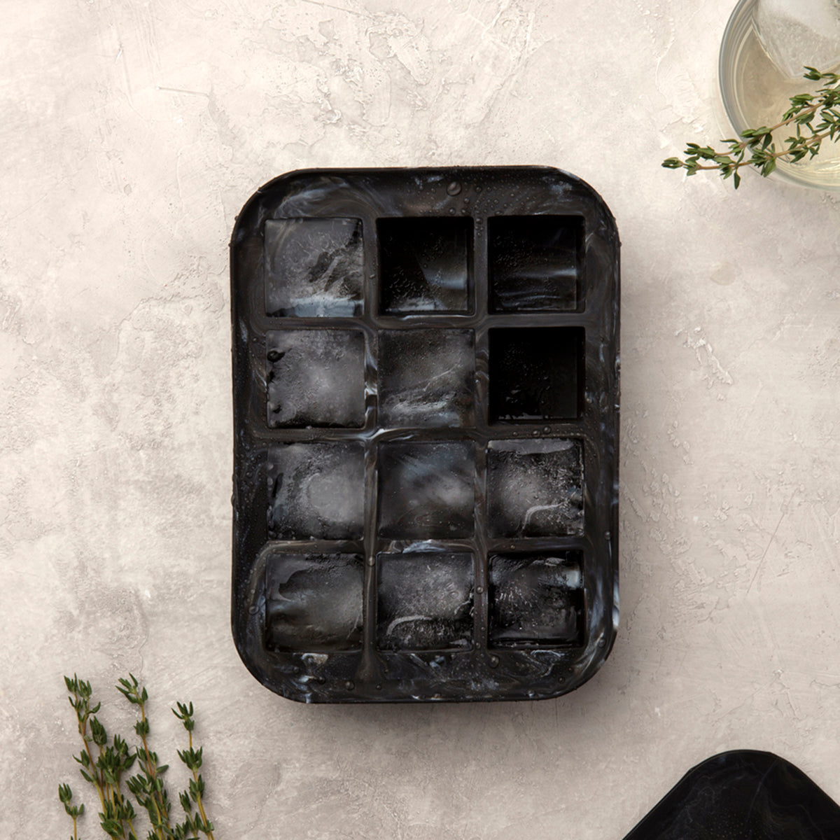 WP black marble everyday ice cube tray with ice inside on off white background