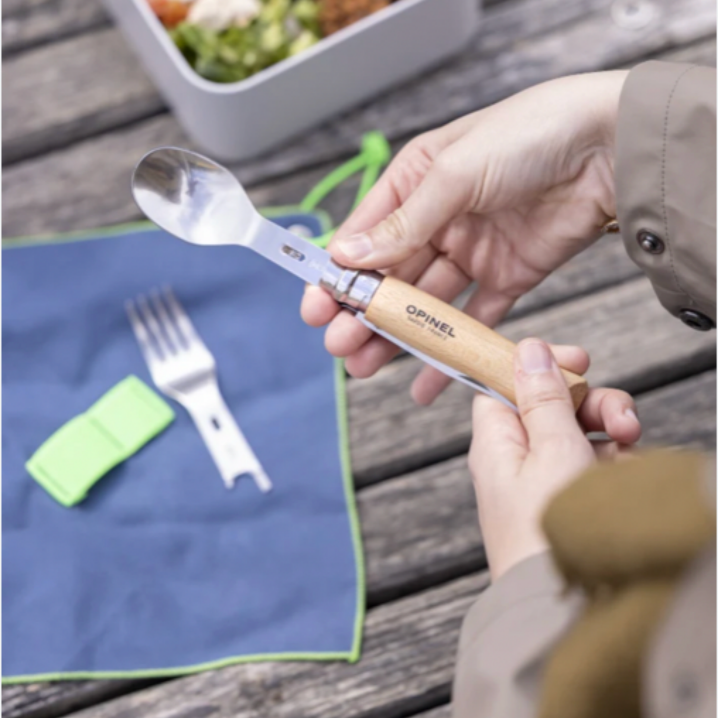 Woman using opinel Picnic Complete Set w/No8 Knife SS Beech at wooden table with packed lunch