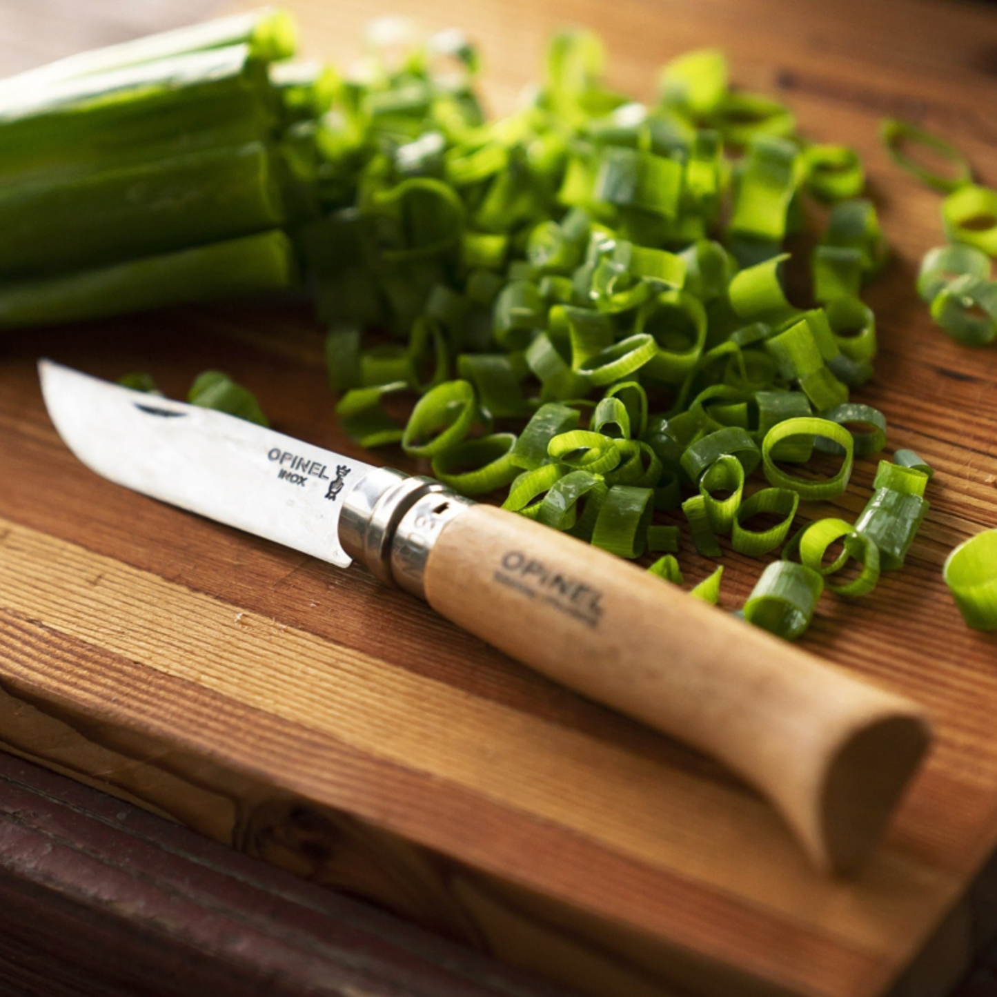 Opinel Traditional Folding Knife No8 Carbon Steel Beech cutting spring onions on chopping board