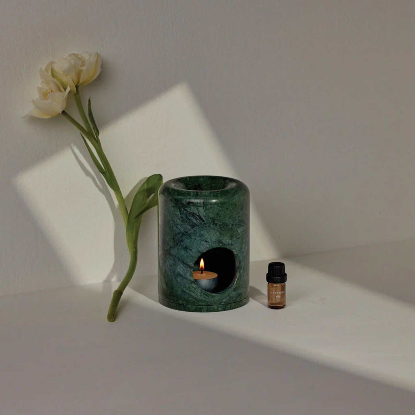 Addition Studios oil burner styled with flower and tea light candle