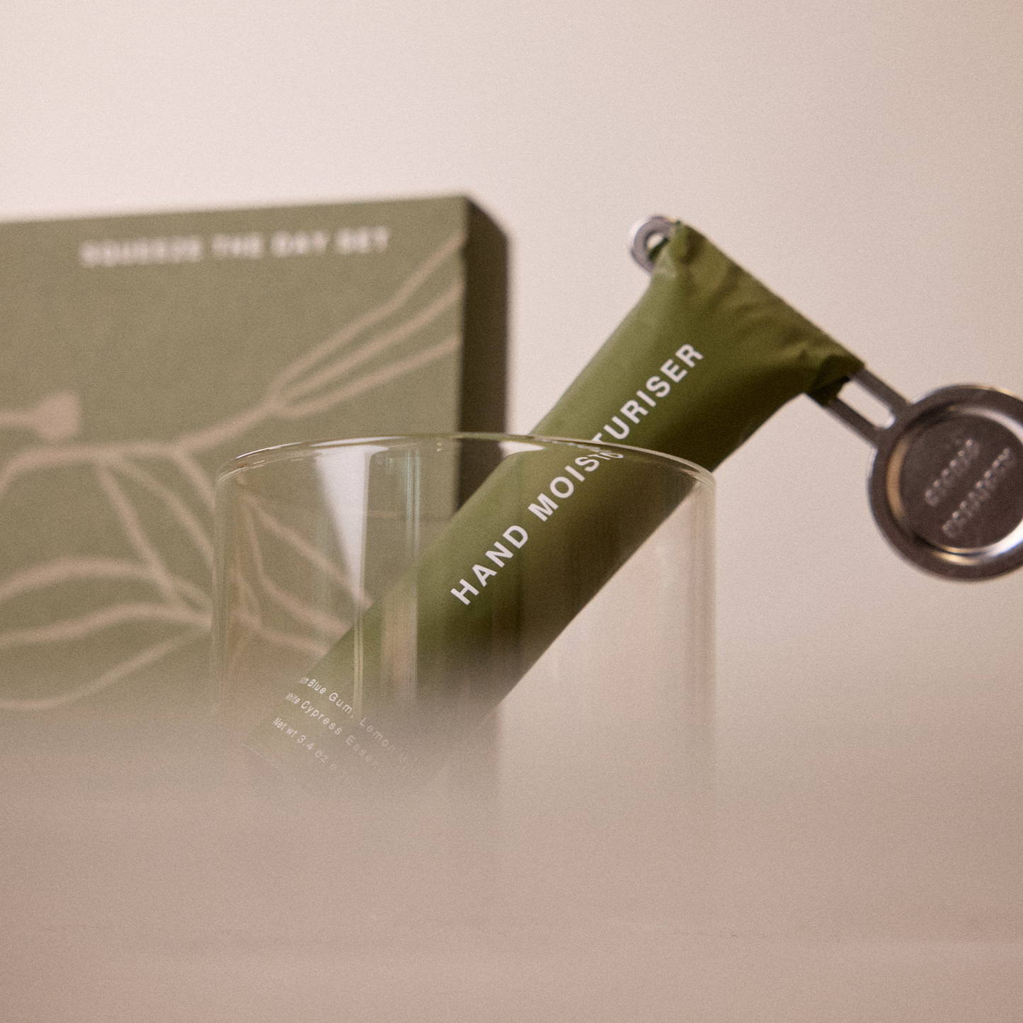 Showing the tube squeezer attached to the hand moisturizer from Addition Studio Squeeze the Day Set: Includes Hand Moisturiser (100ml) and Lip Balm (15ml) with plant-based formulas and 100% natural essential oils. Features aluminium tubes with a zinc alloy tube squeezer.
