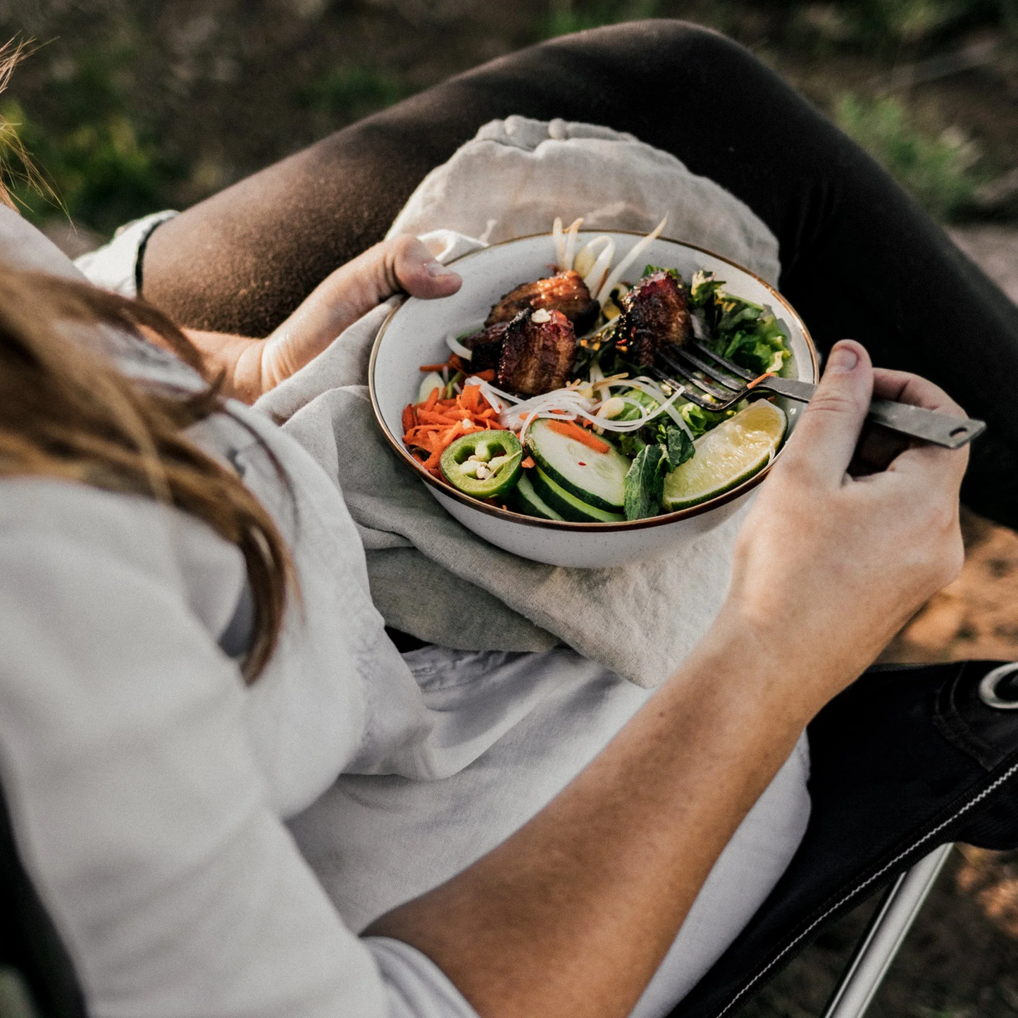 Woman eating a salad out of Barebones enamel bowl eggshell