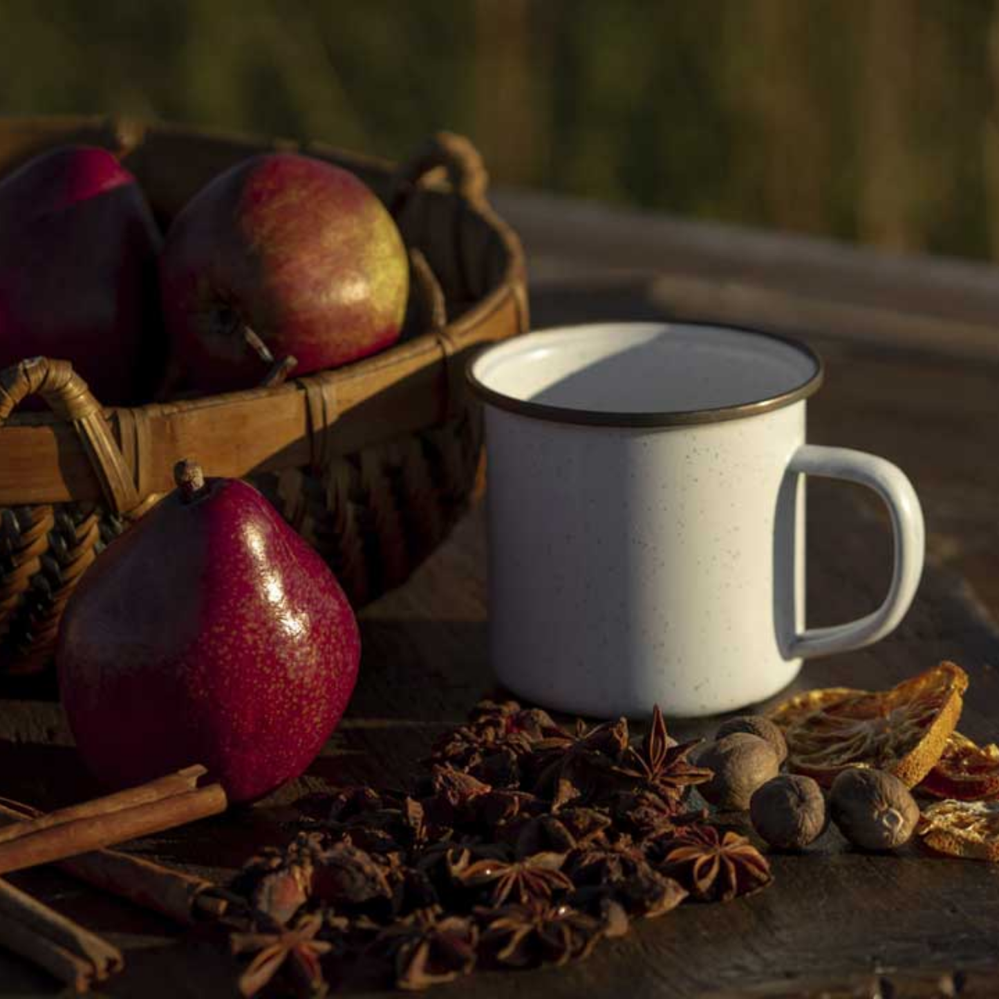 Barebones enamel cup outdoors on wooden table with pears side view