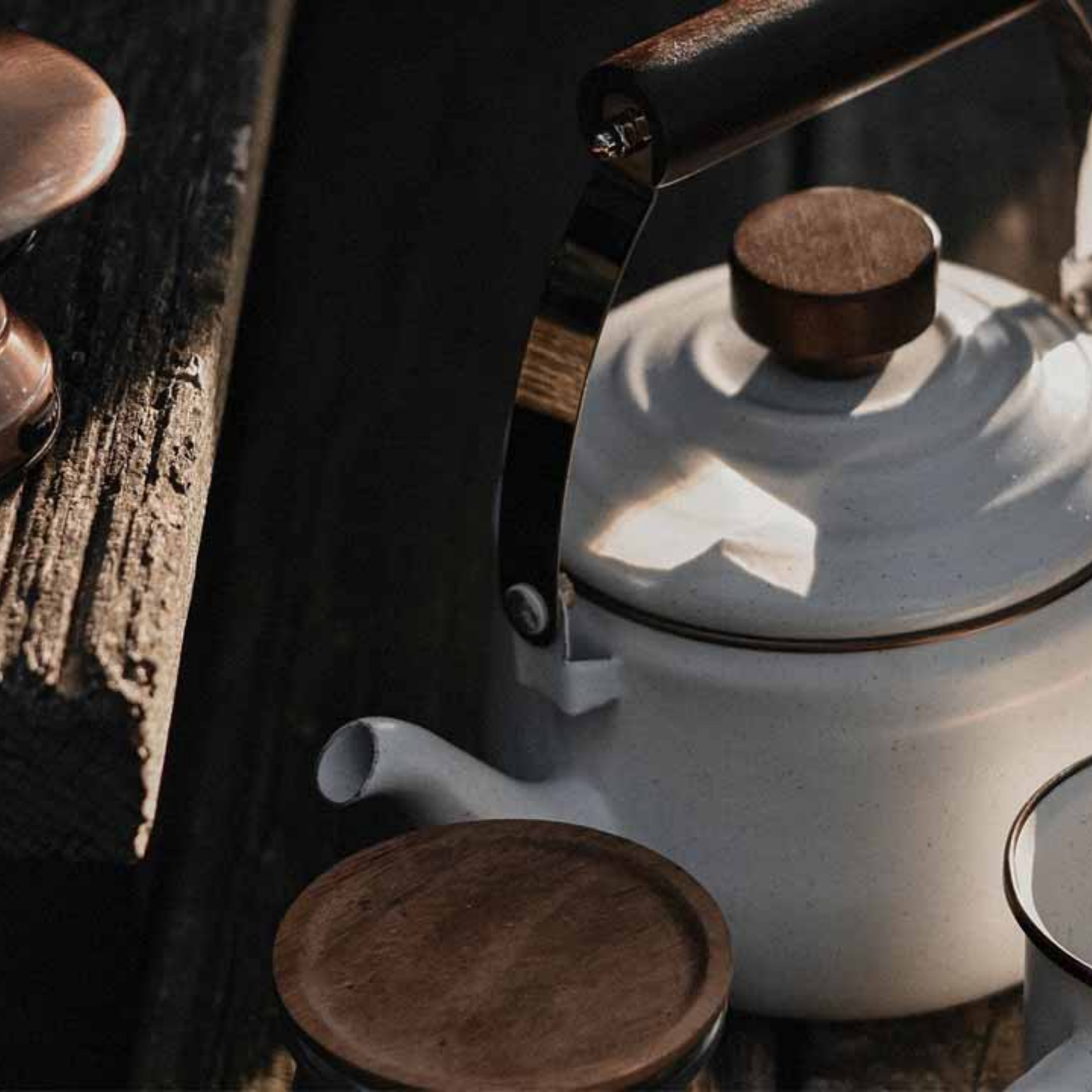 Barebones enamel teapot eggshell side angled view close up outside on wood table
