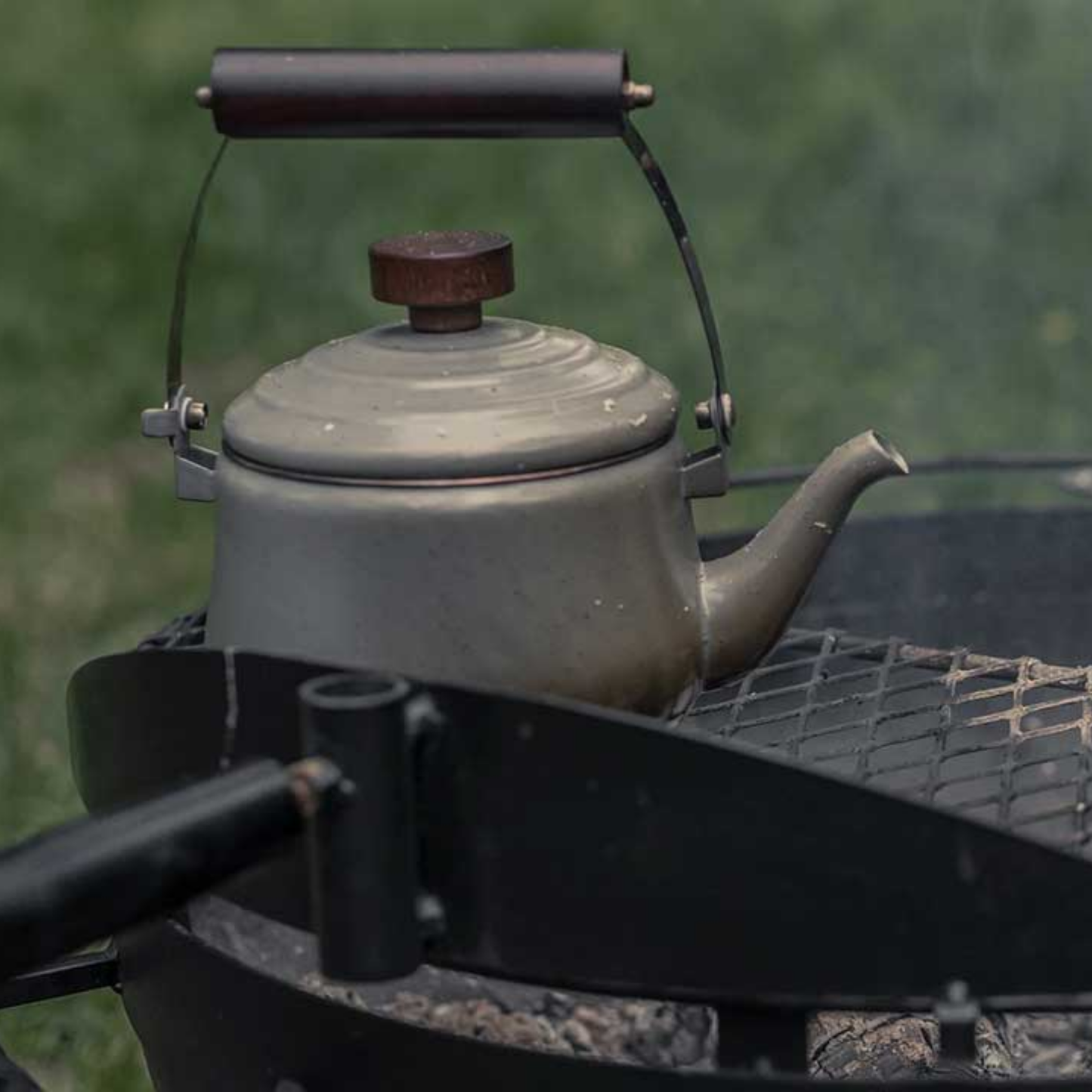 Barebones enamel teapot slate grey side view on camping grill outdoors
