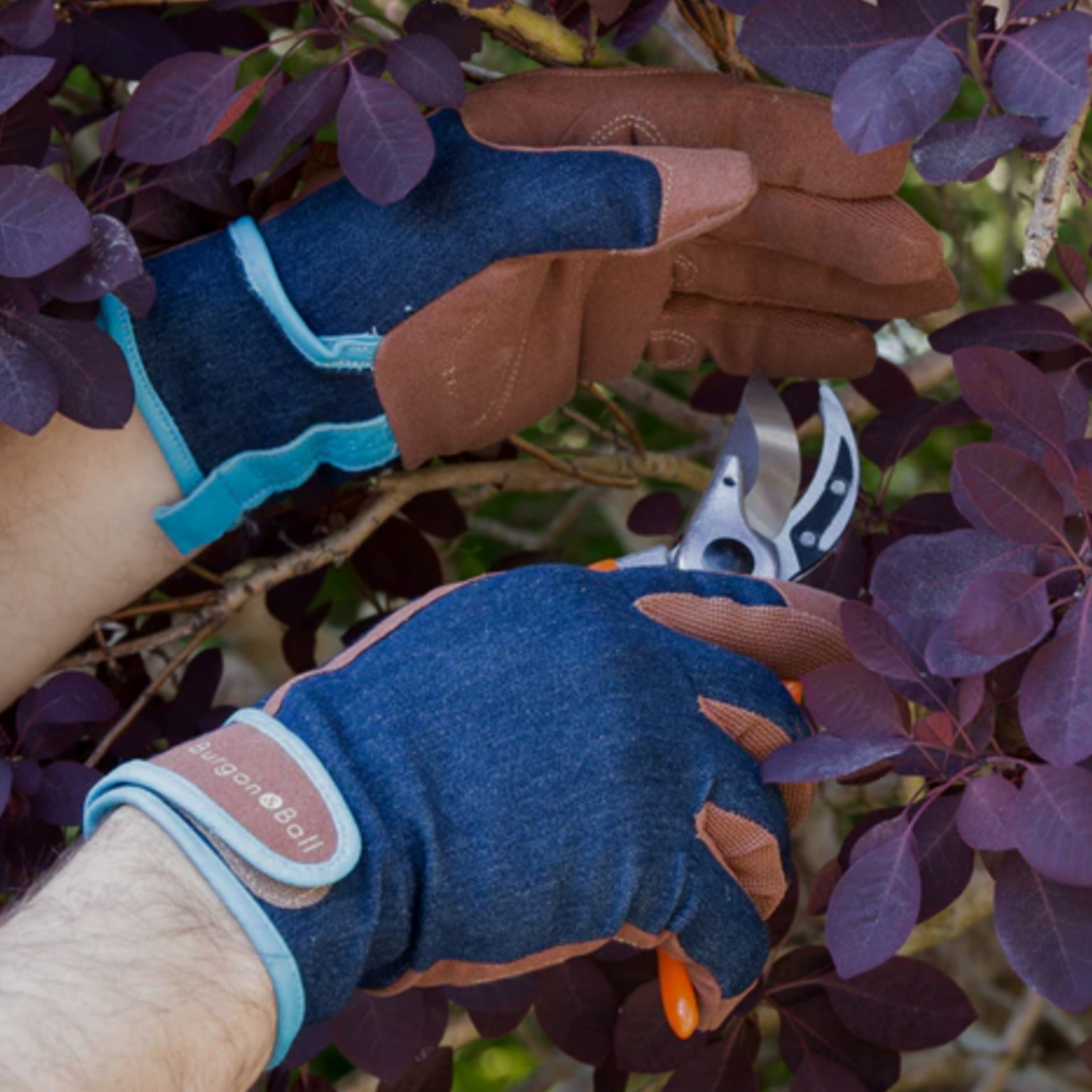Man using denim gardening gloves and grooming plants in garden