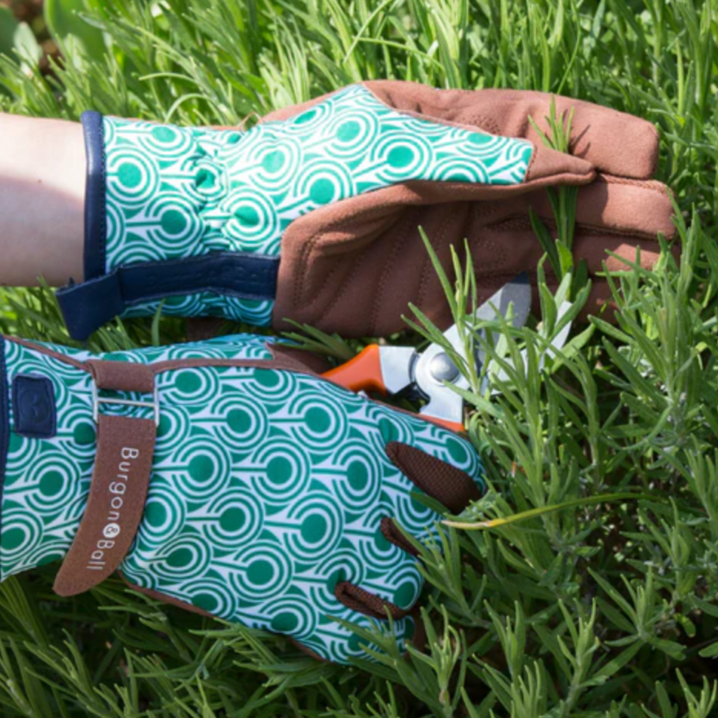 Man using deco gardening gloves and grooming grass in garden