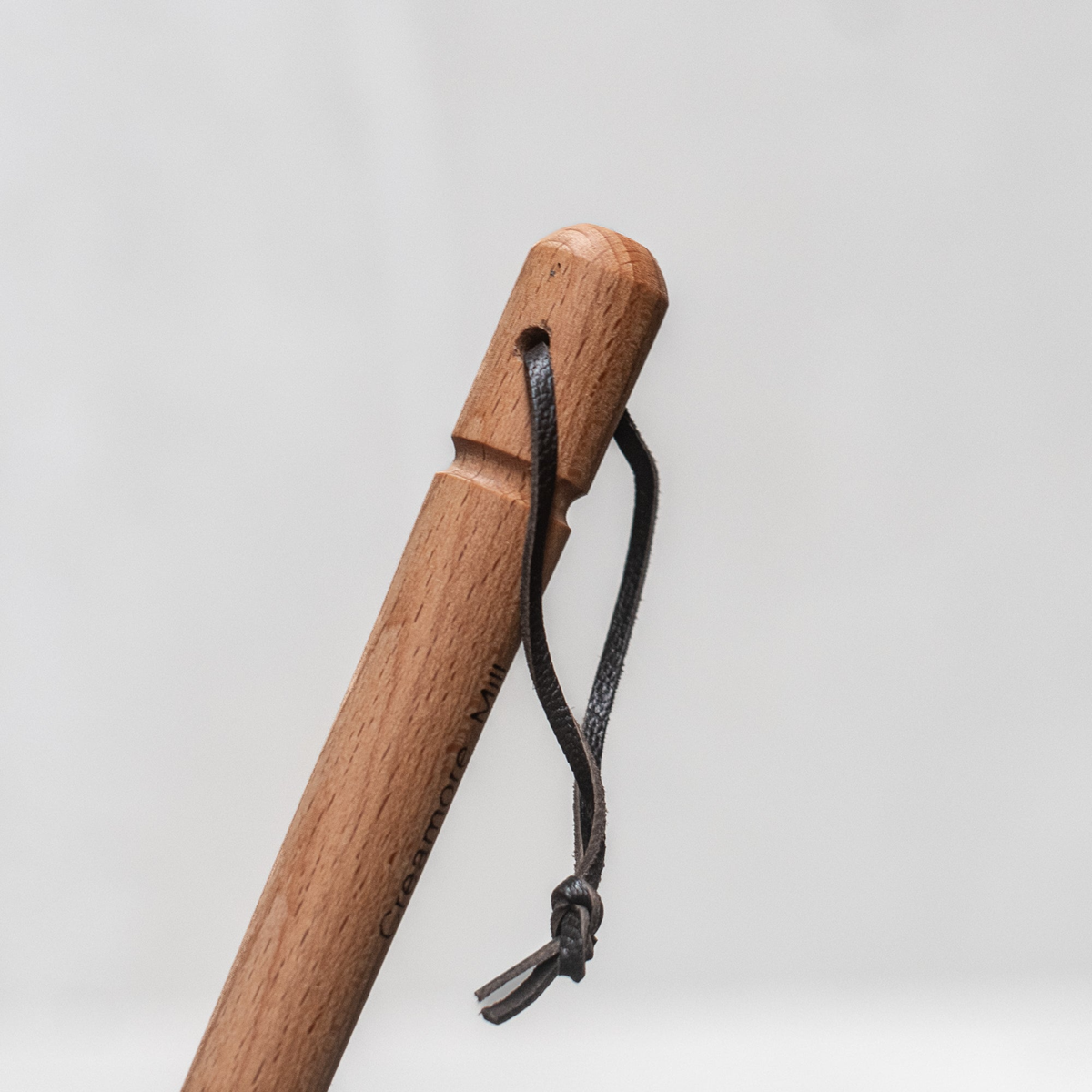 Wooden handle with the hanging loop at the bottom from Fathom natural leather fly swatter with beechwood handle, 53cm durable and gentle insect control tool for kitchens, patios, and outdoor dining.
