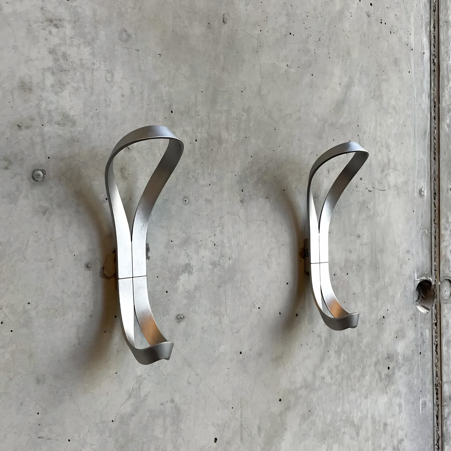 Close up view of two Essem Endless Hook Aluminium designed by Anna von Schewen, from recycled aluminum hung on the wall.