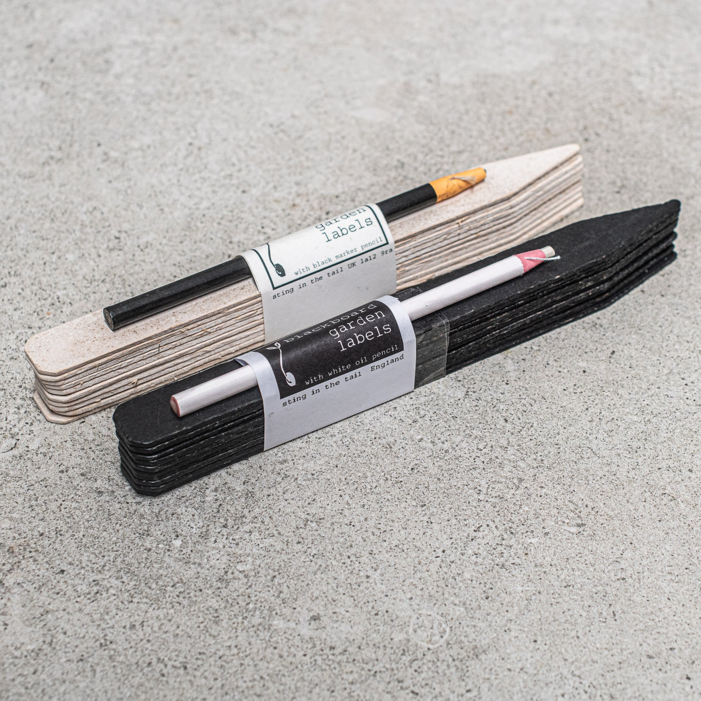 Black garden lables with white pencil in packaging next to white garden labels in packaging