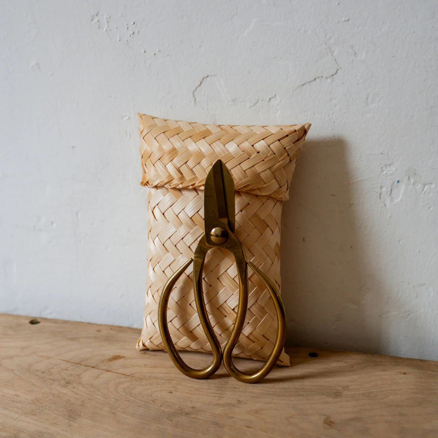 Garden scissors in front of bamboo packaging bag front view on woodenn table