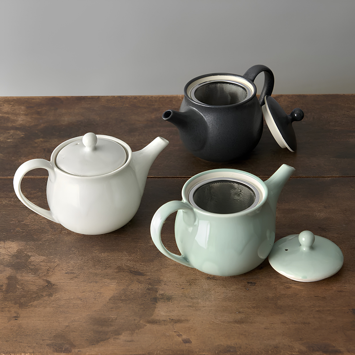 Three pots on the table with the Fathom Japanese Teapot in matt black, ceramic with satin glaze, rounded form and graceful spout for smooth pouring.