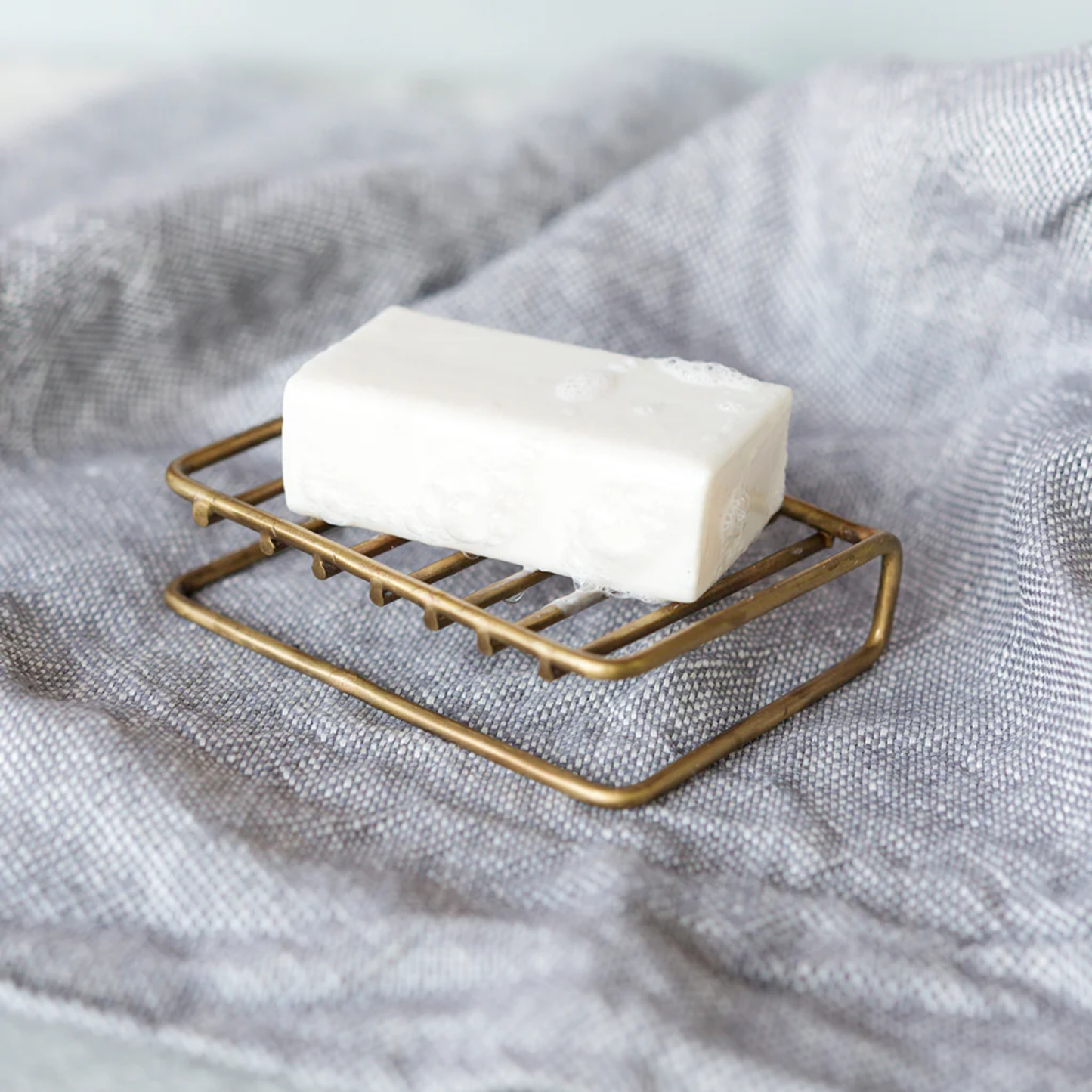 Fog Linen brass soap stand front on display on tea towel close up view