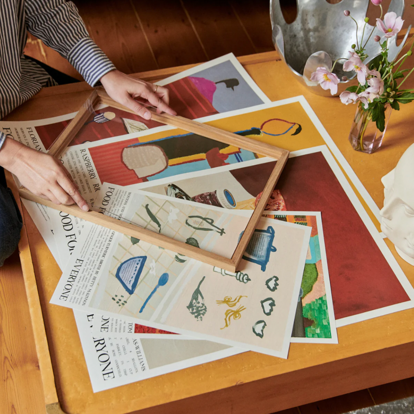 Woman framing artworks with Food For Everyone A2 frame