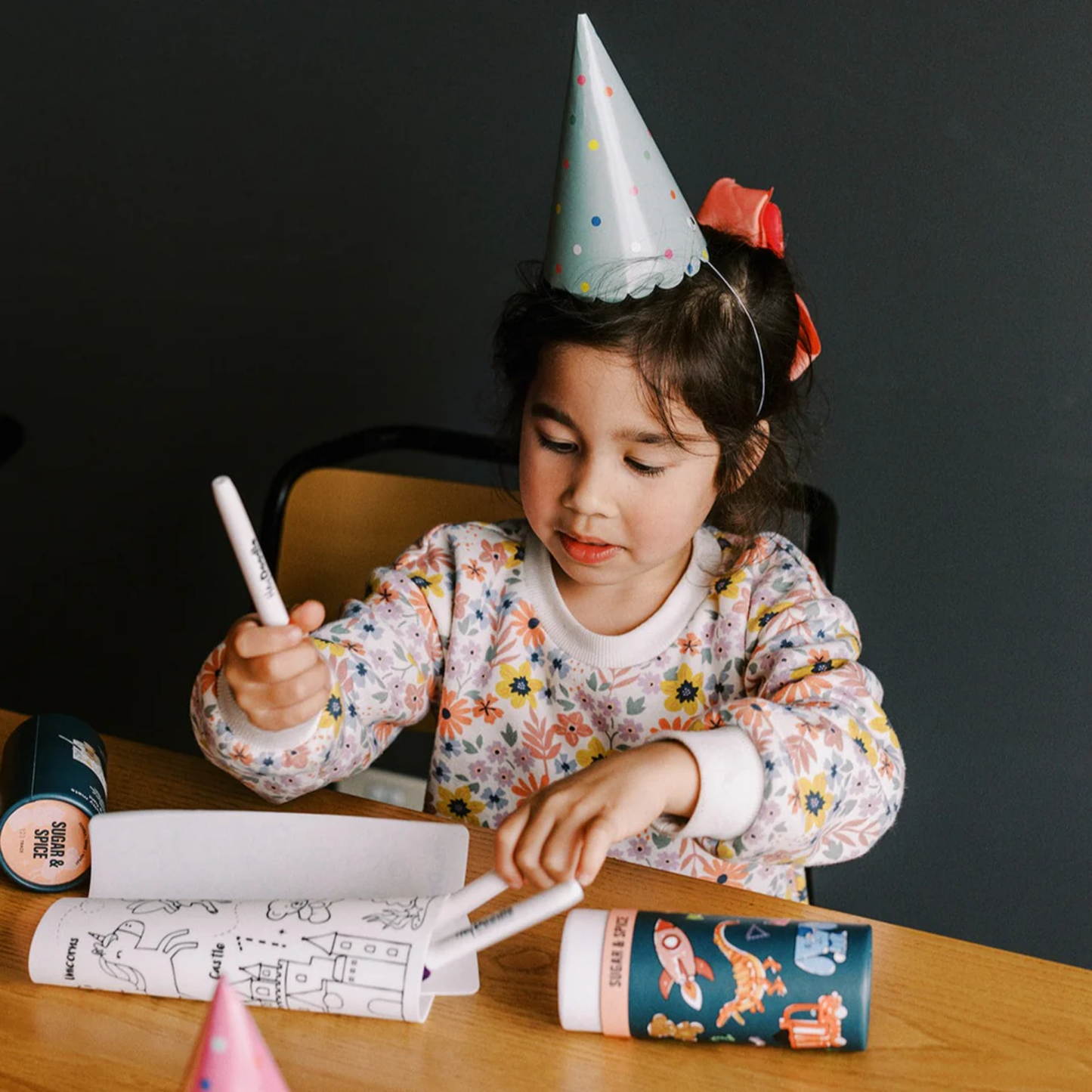 Young girl in party hat drawing with Hey Doodle