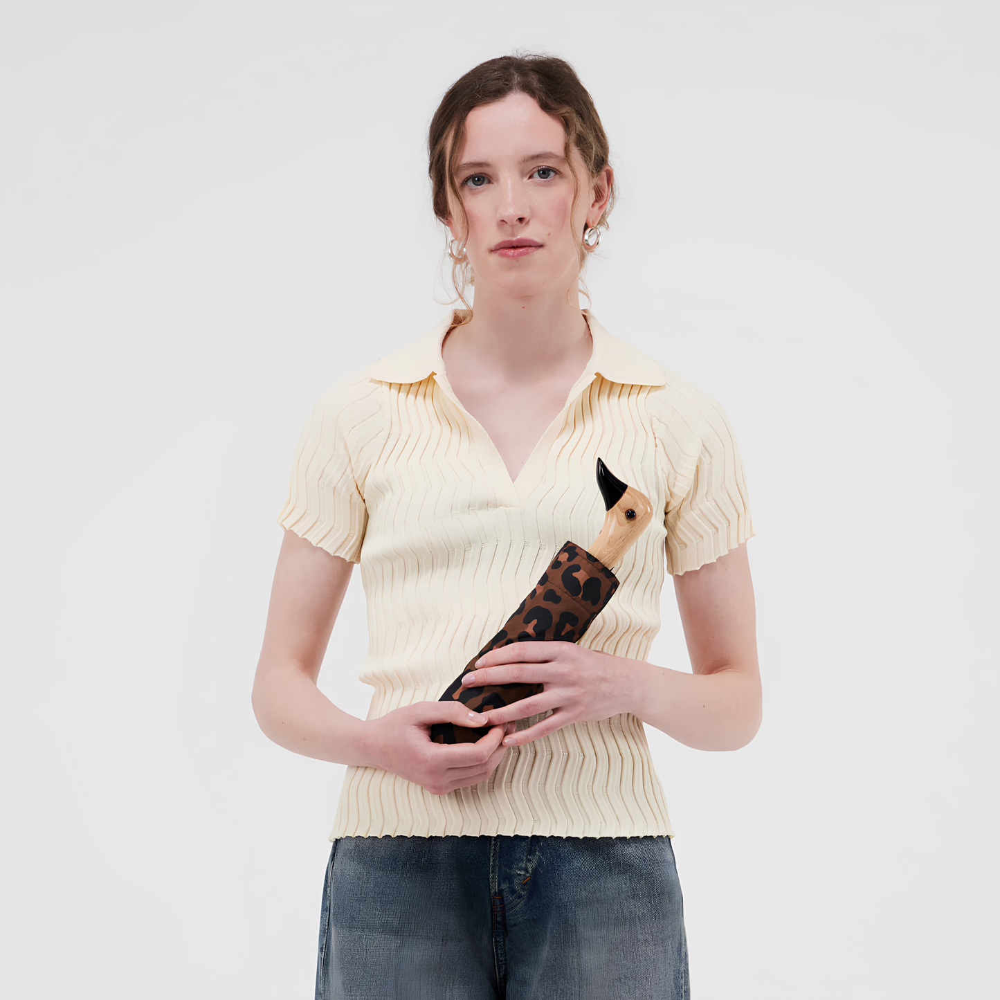 A woman holding the kept Original Duckhead Duck Umbrella Compact Leopard timeless animal print design from sustainable materials.
