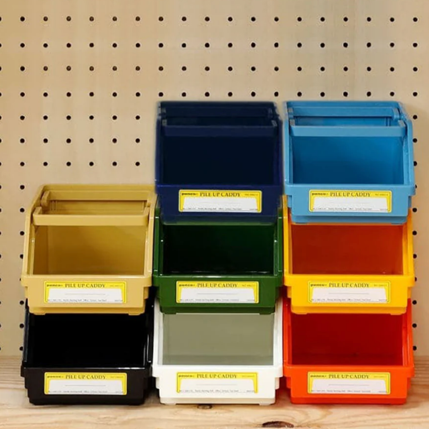 Assorted Penco pile up caddys stacked infront of peg board