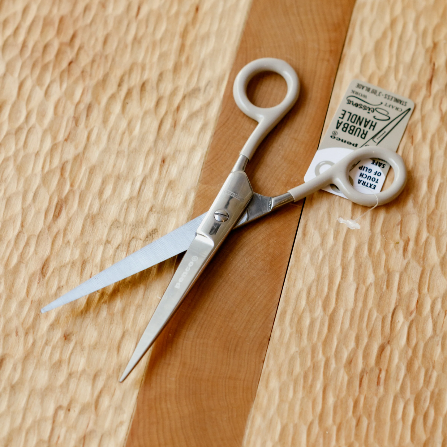 Penco large ivory scissors open on wooden table