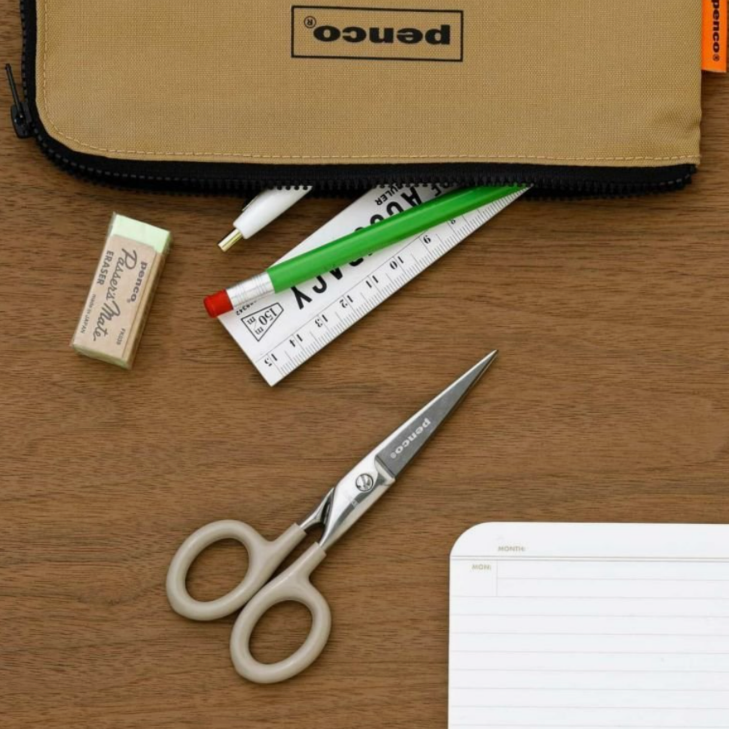 Penco small ivory scissors on wooden table with stationery