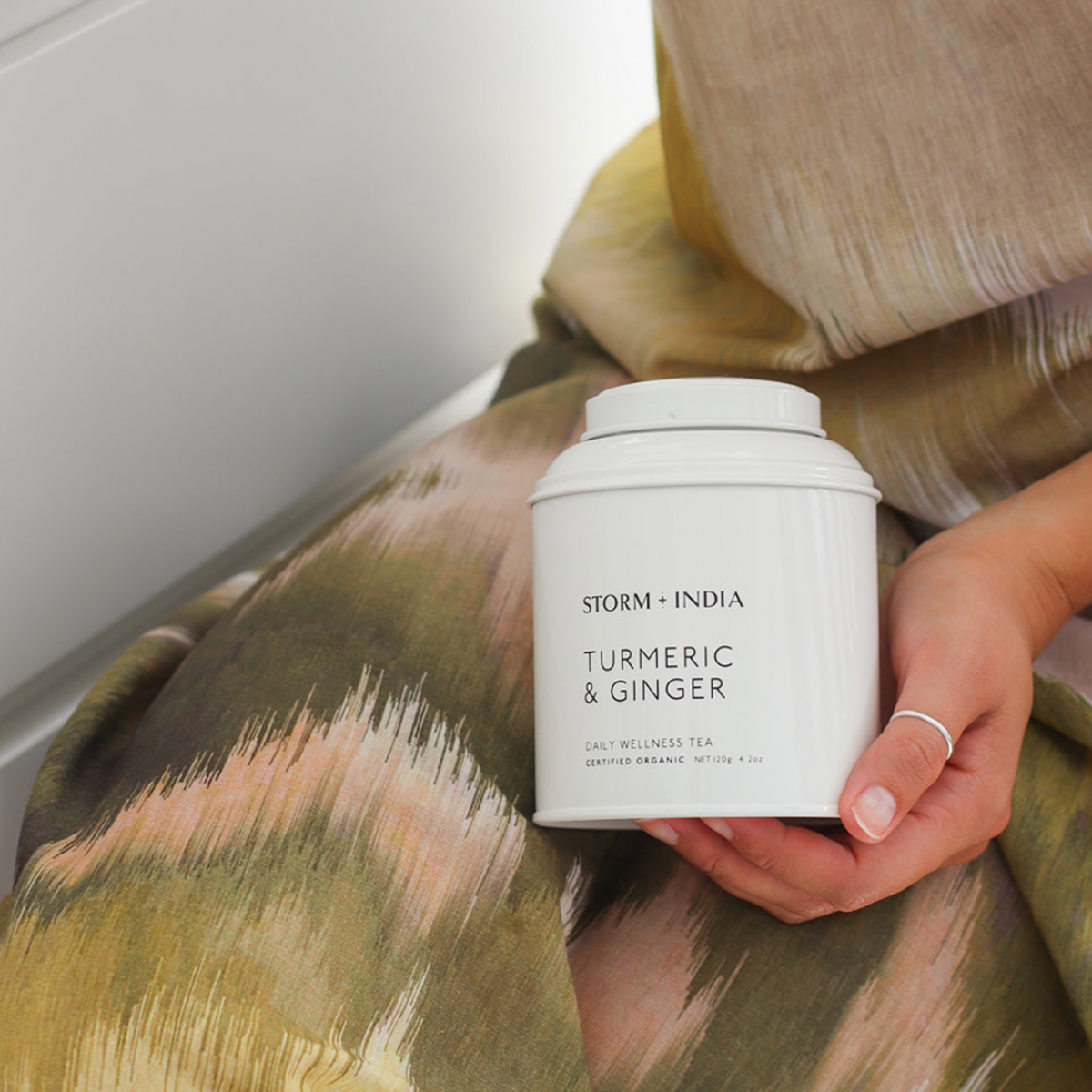 Woman resting Storm and India Loose Leaf Tea in Tin 150g Tumeric & Ginger on her lap in hand