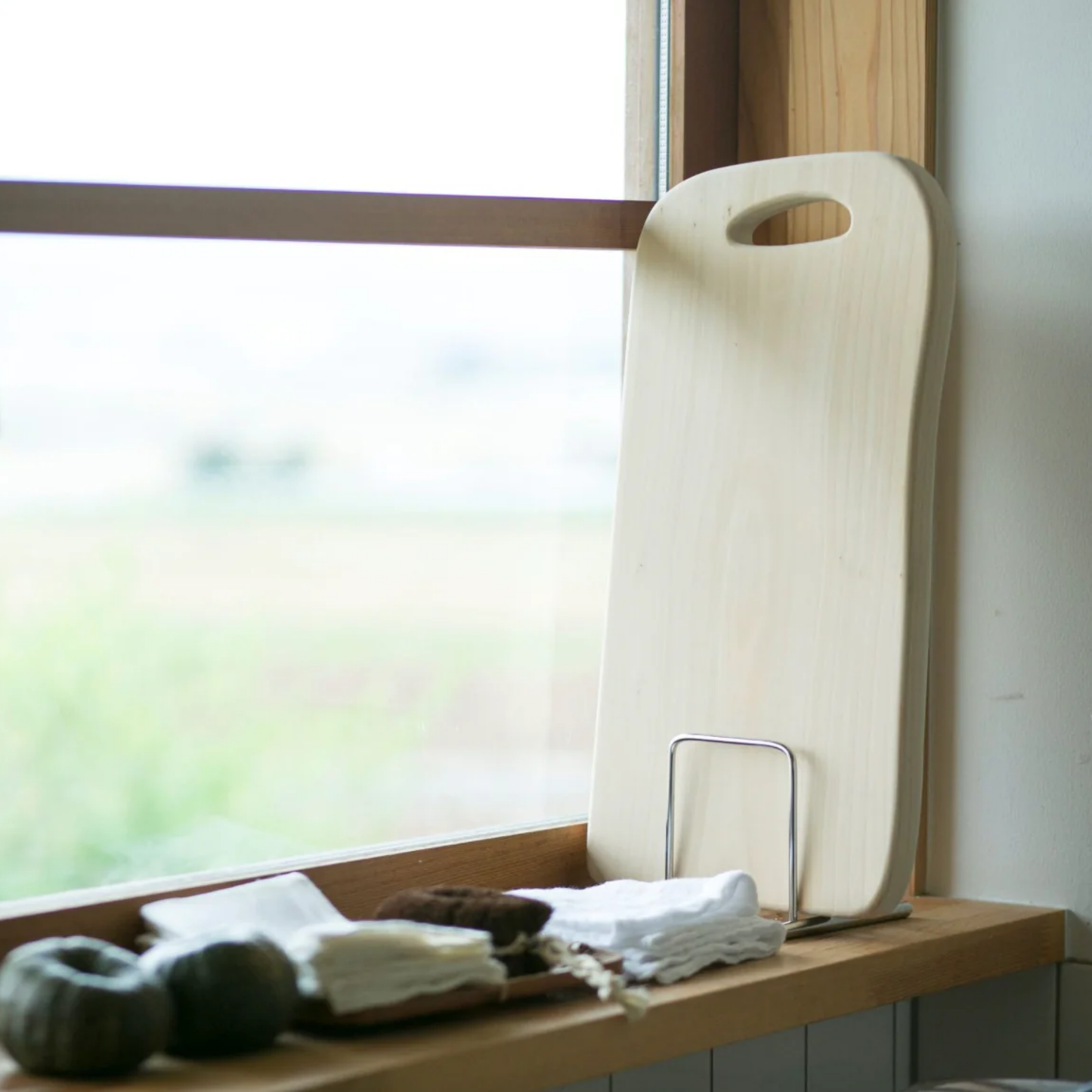 Woodpecker Manaita chopping board stand on display on kitchen window sill with large Manaita chopping board in stand