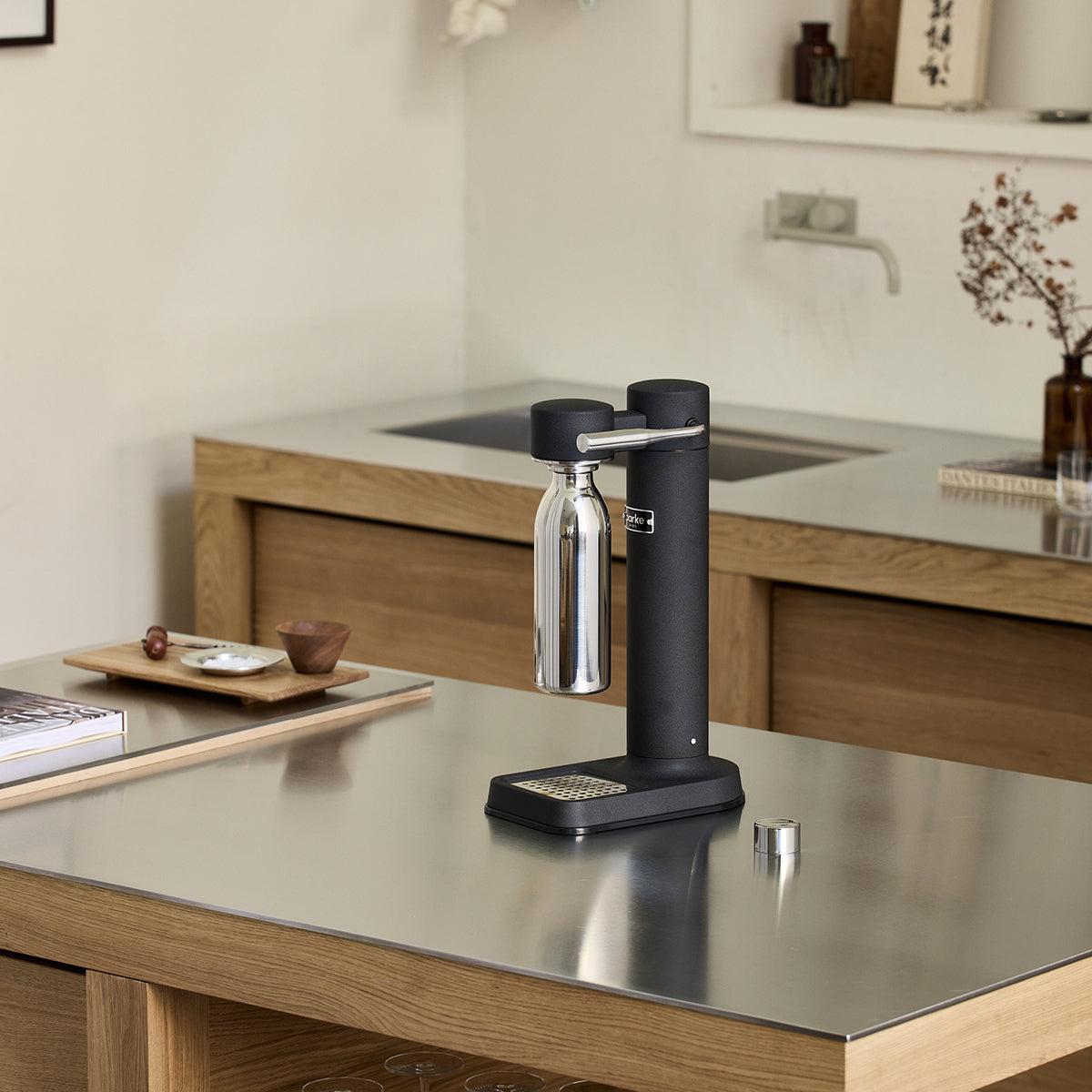 650ml Stainless steel Carbonator 3 bottle on wood shelf in front of black bag and sunglasses