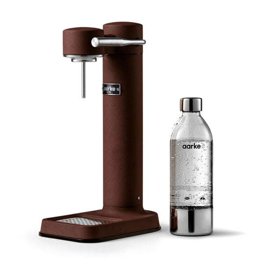 Stylish sparkling water maker designed by Aarke in Sweden showing the matte burgundy finish and the included 650ml PET water bottle