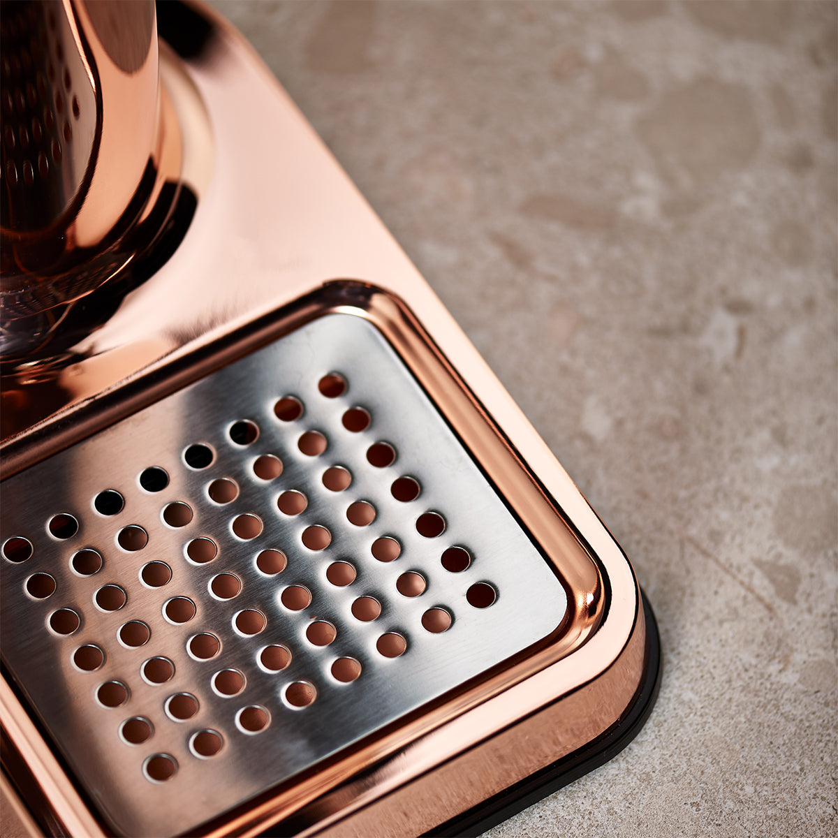 Close up of stylish sparkling water maker designed by Aarke in Sweden showing the copper finish and the stainless steel drip tray