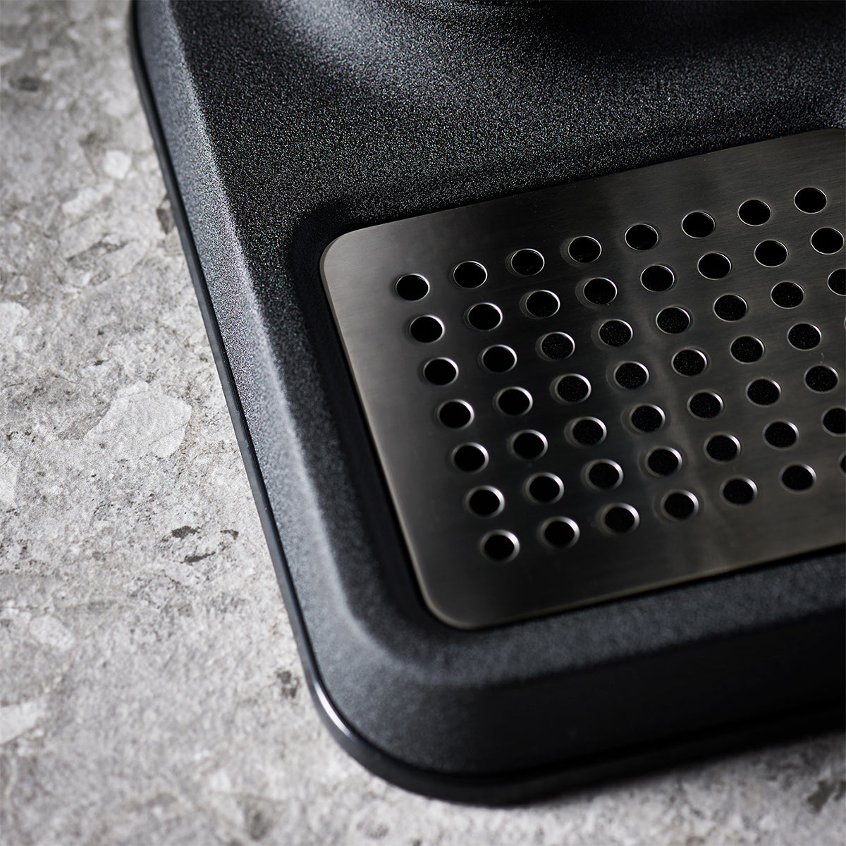 Close up of stylish sparkling water maker designed by Aarke in Sweden showing the matte black finish and the stainless steel drip tray