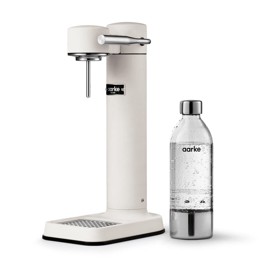 Stylish sparkling water maker designed by Aarke in Sweden showing the matte white finish and the included 650ml PET water bottle