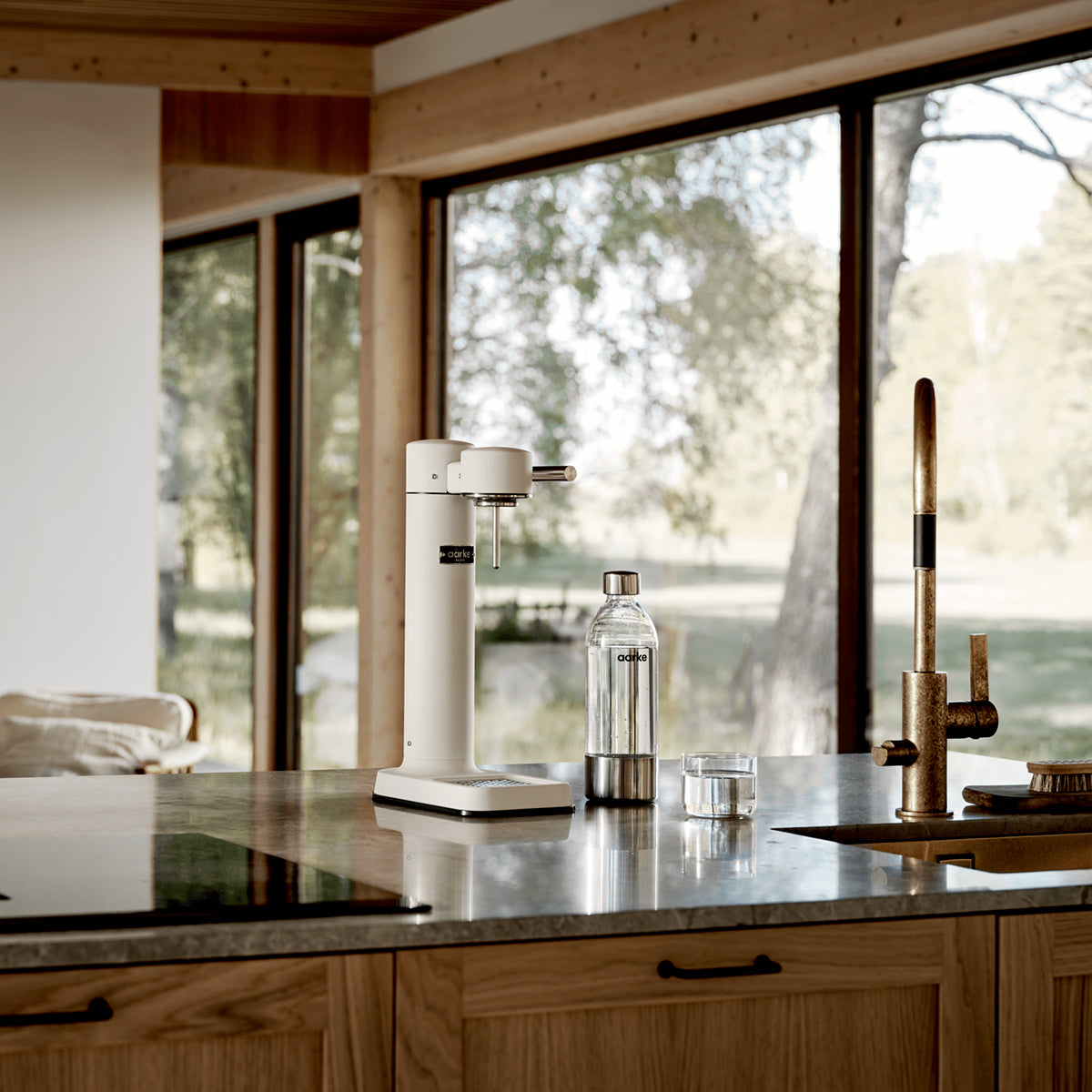 Close up of stylish sparkling water maker designed by Aarke in Sweden showing the matte white finish and displayed on the kitchen bench