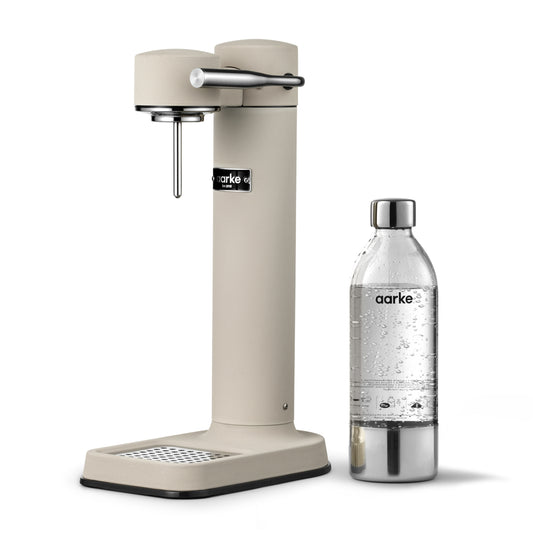 Stylish sparkling water maker designed by Aarke in Sweden showing the sand finish and the included 650ml PET water bottle
