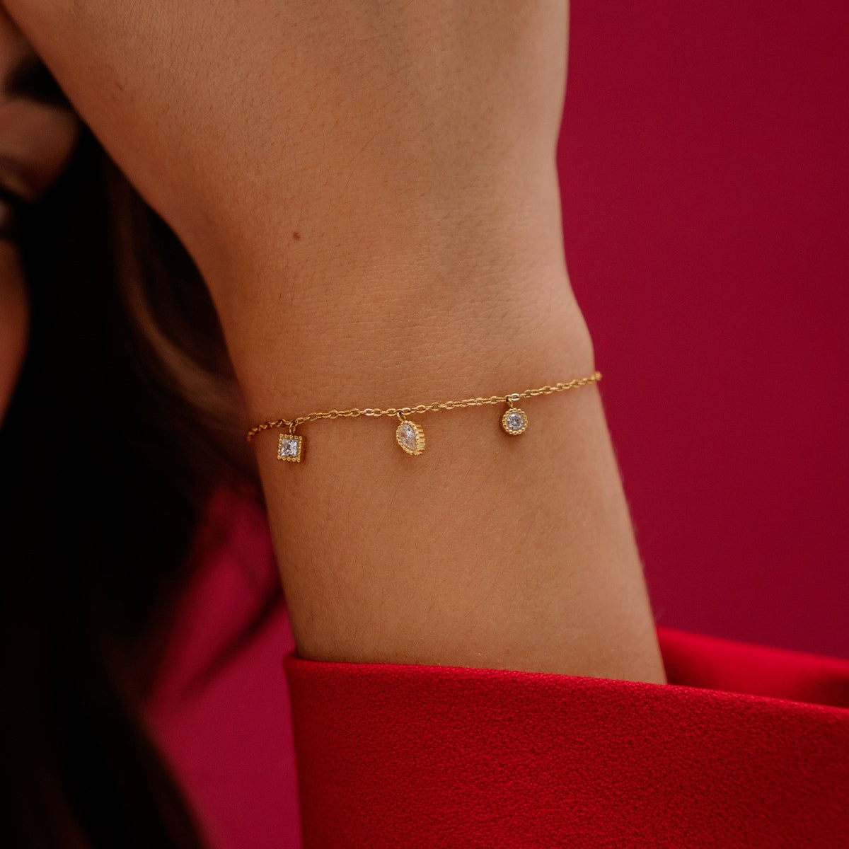 On a womans wrist, AEC Paris Anya White Zirconium Oxide bracelet - 3-stone droplet bracelet with white cubic zirconia on 14k gold-plated stainless steel, hypoallergenic and durable everyday jewellery, minimalist elegant design.