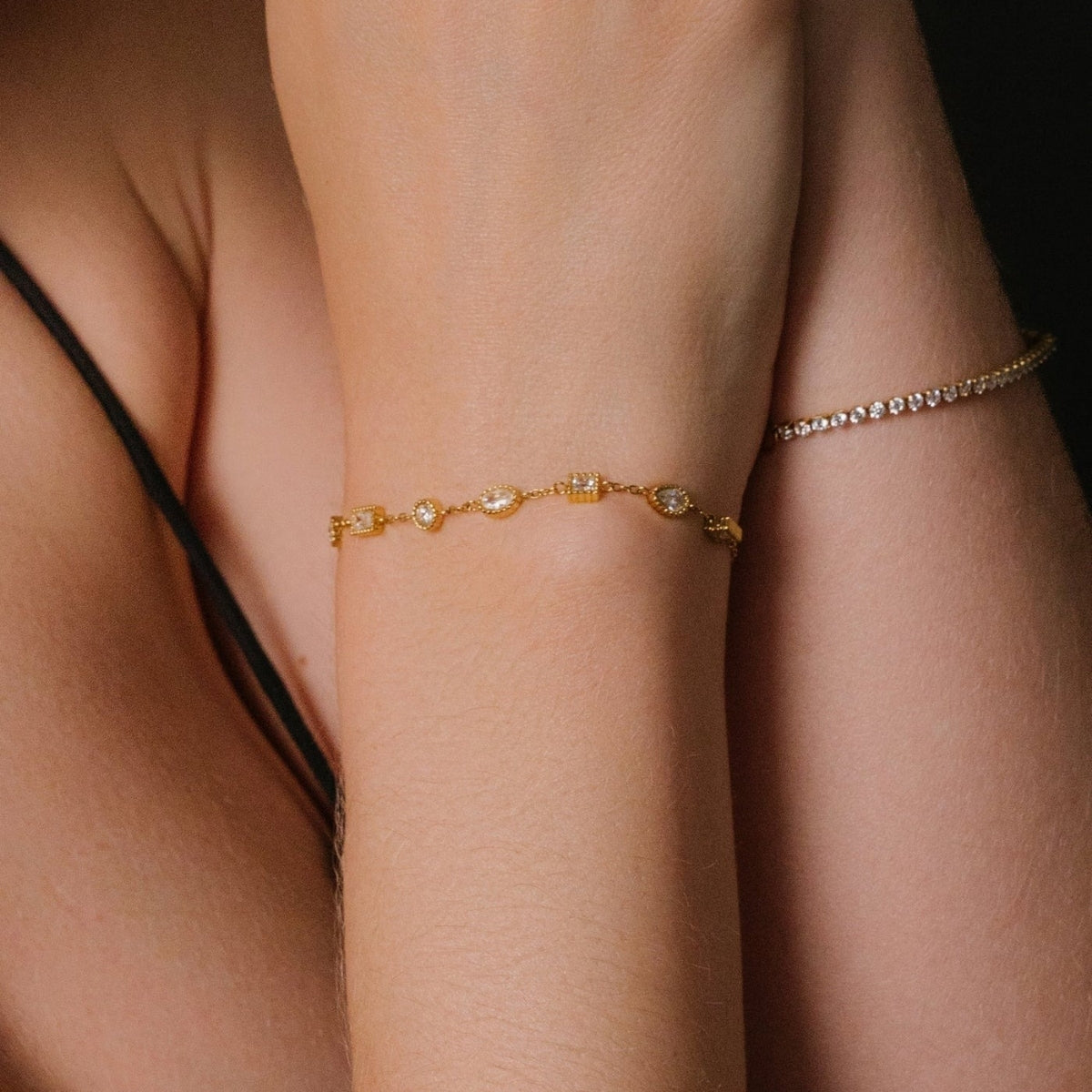 Showing on the wrist AEC Paris Nila bracelet - gold multi-stone station bracelet in 14k gold-plated stainless steel, polished gold colour material featuring white cubic zirconia stones for a sparkling, elegant finish.