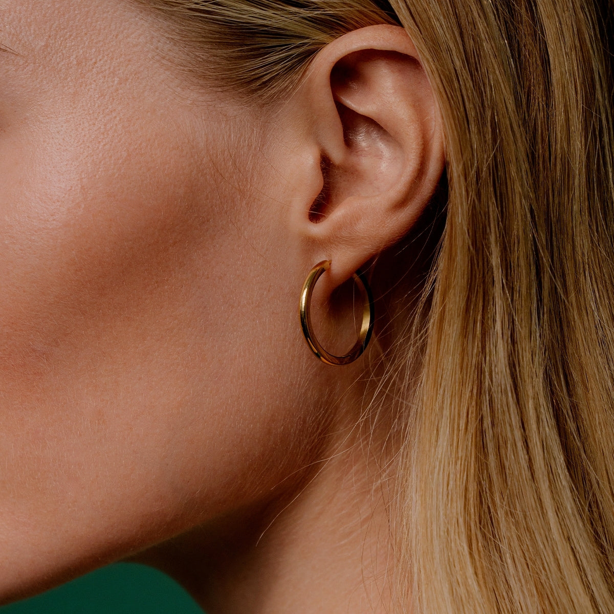 AEC Paris Ananya Gold earring left ear close up on woman with blonde hair