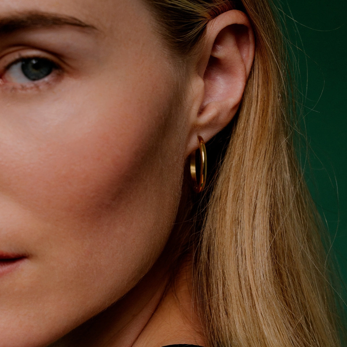close up of Blonde hair woman wearing AEC Paris Ananya Gold earrings showing left hand side of face