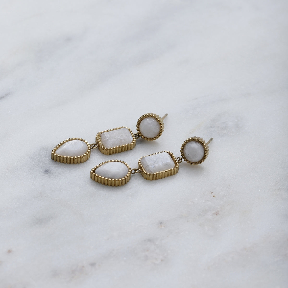 AEC Paris Persephone Moonstone drop earrings laying on white marble 