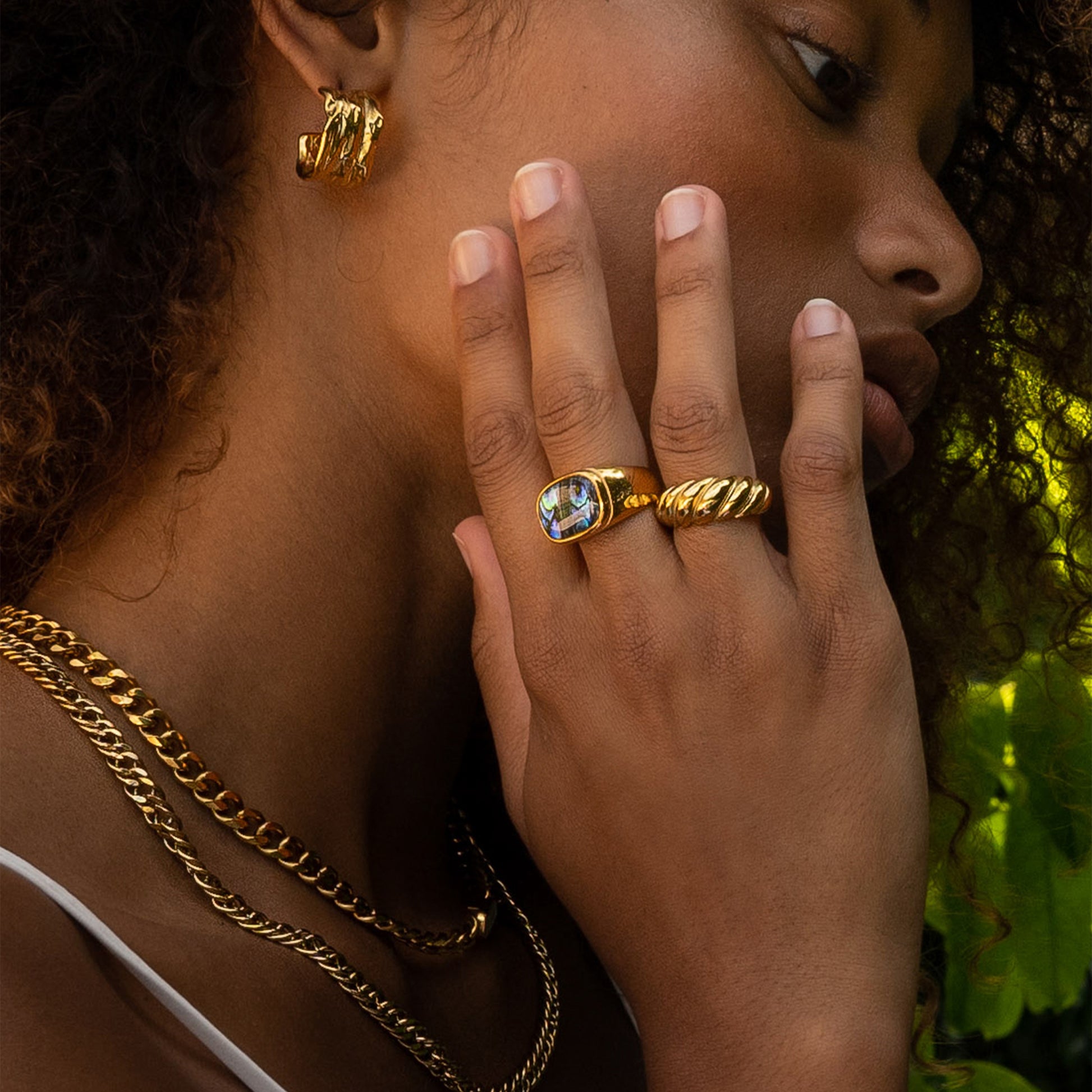 A woman showing her rings with the size 6 AEC Paris Aquarius Gold ring - solid croissant ring in 18k gold-plated stainless steel, durable, hypoallergenic, minimalist design, luxury everyday jewellery.