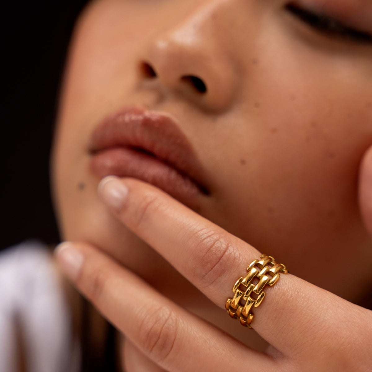 Clouse up of woman with AEC Paris Elisa Gold size 8 ring on finger touching her mouth