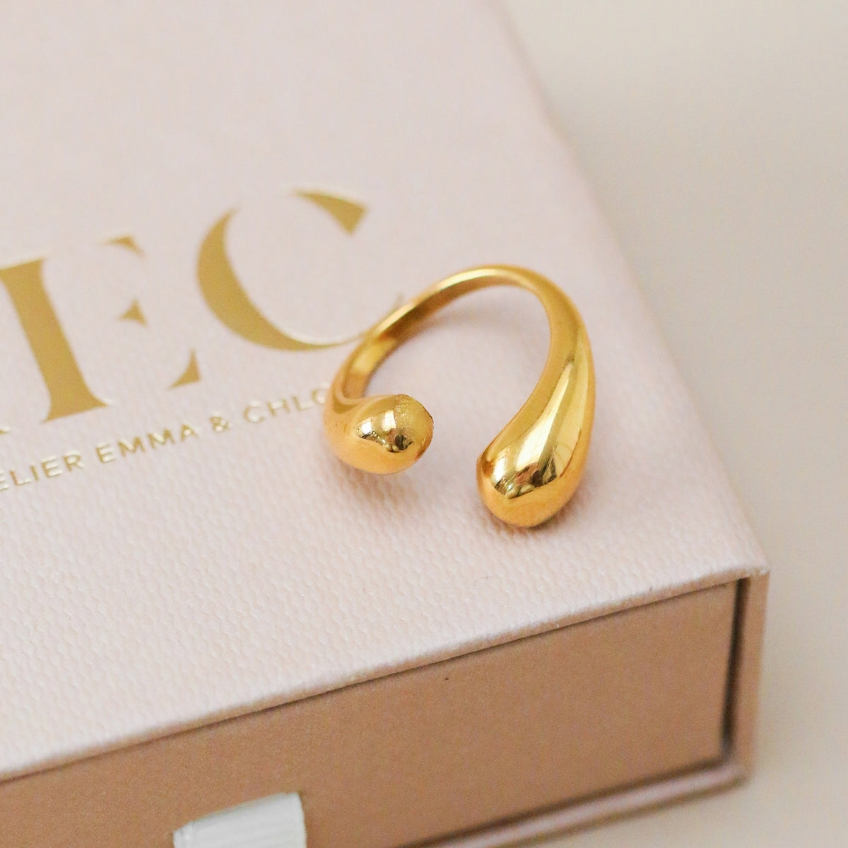 AEC Paris Irene Gold size 5-7 ring sitting on top of gift box