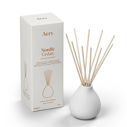 Aery Nordic Cedar 200ml diffuser from the Fernweh collection showing diffuser and packaging on white table with white sculpture