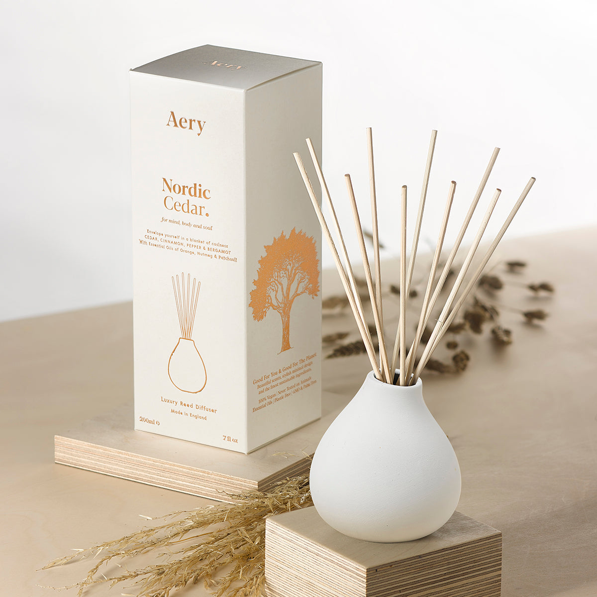 Aery Nordic Cedar 200ml diffuser from the Fernweh collection showing diffuser and packaging on an angle on a white shelf with sculpture