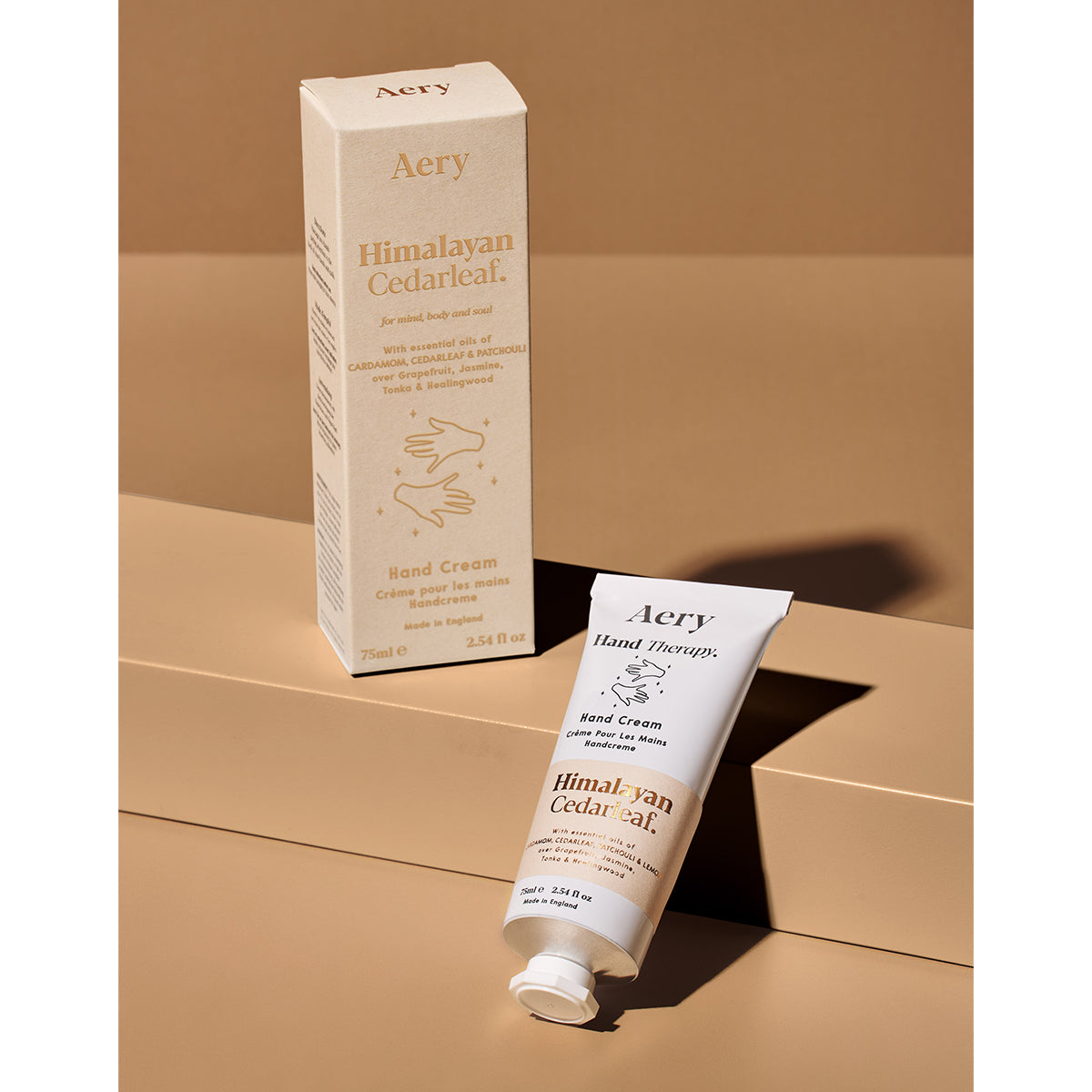 Aery 75ml Himalayan Cedarleaf hand cream from the Fernweh collection showing hand cream and packaging laying on beige background