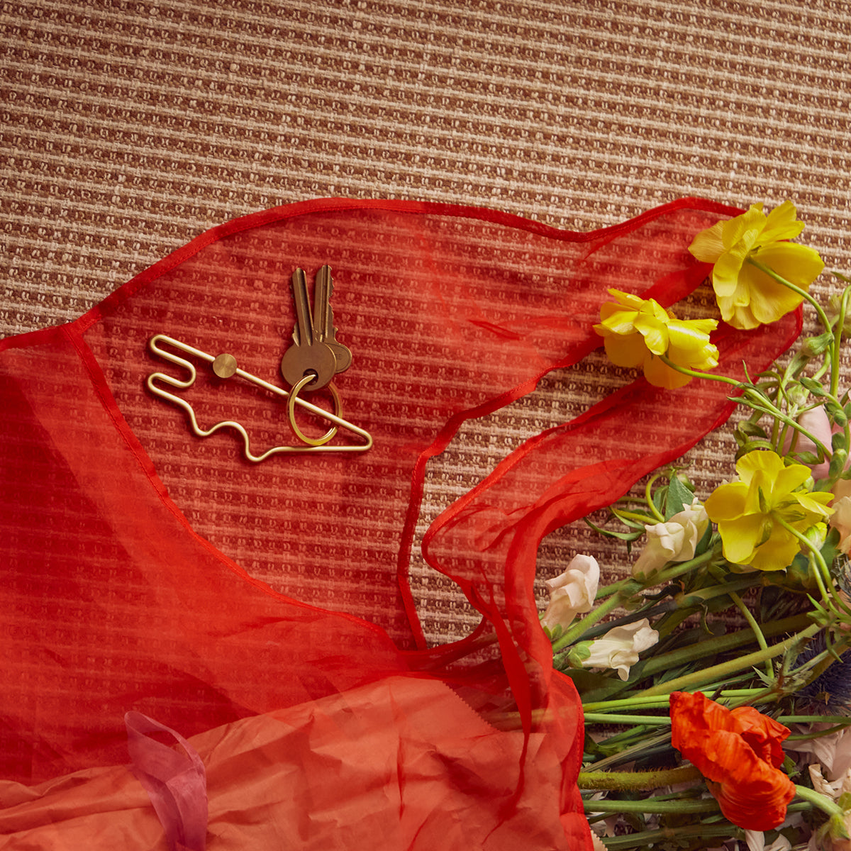 Areaware croc animal keyring on table next to red string bag