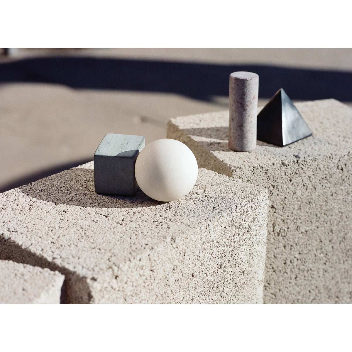 Areaware drink rock whiskey stones in cluster on beige bricks