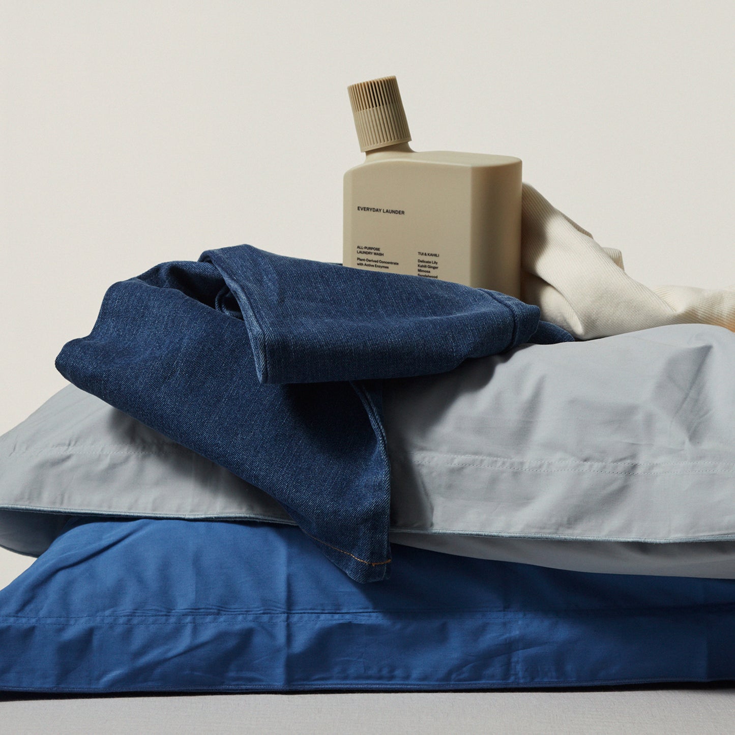 Ashley and Co 'Everyday Launder' laundry detergent bottle in Tui and Kahili fragrance on freshly washed jeans.